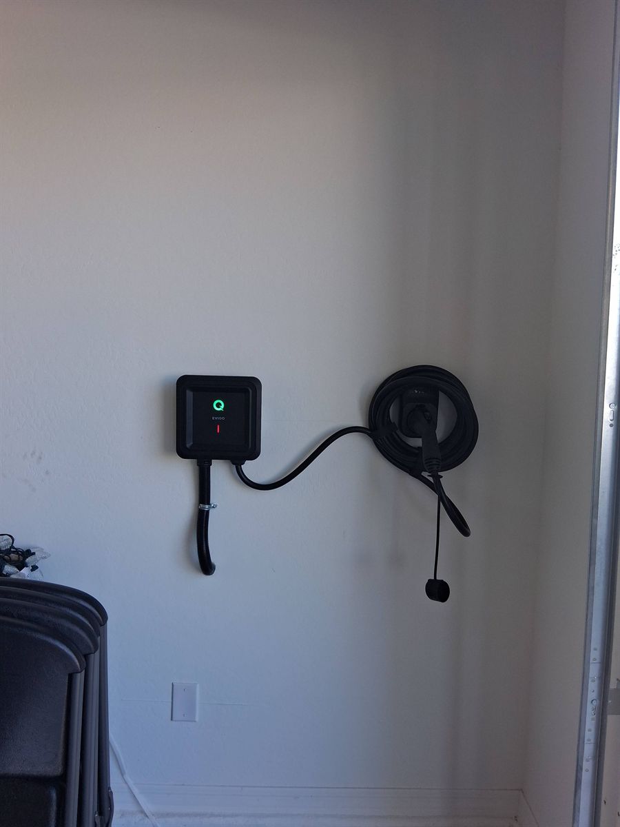 Level 2 charger and cable holster installed on a garage wall