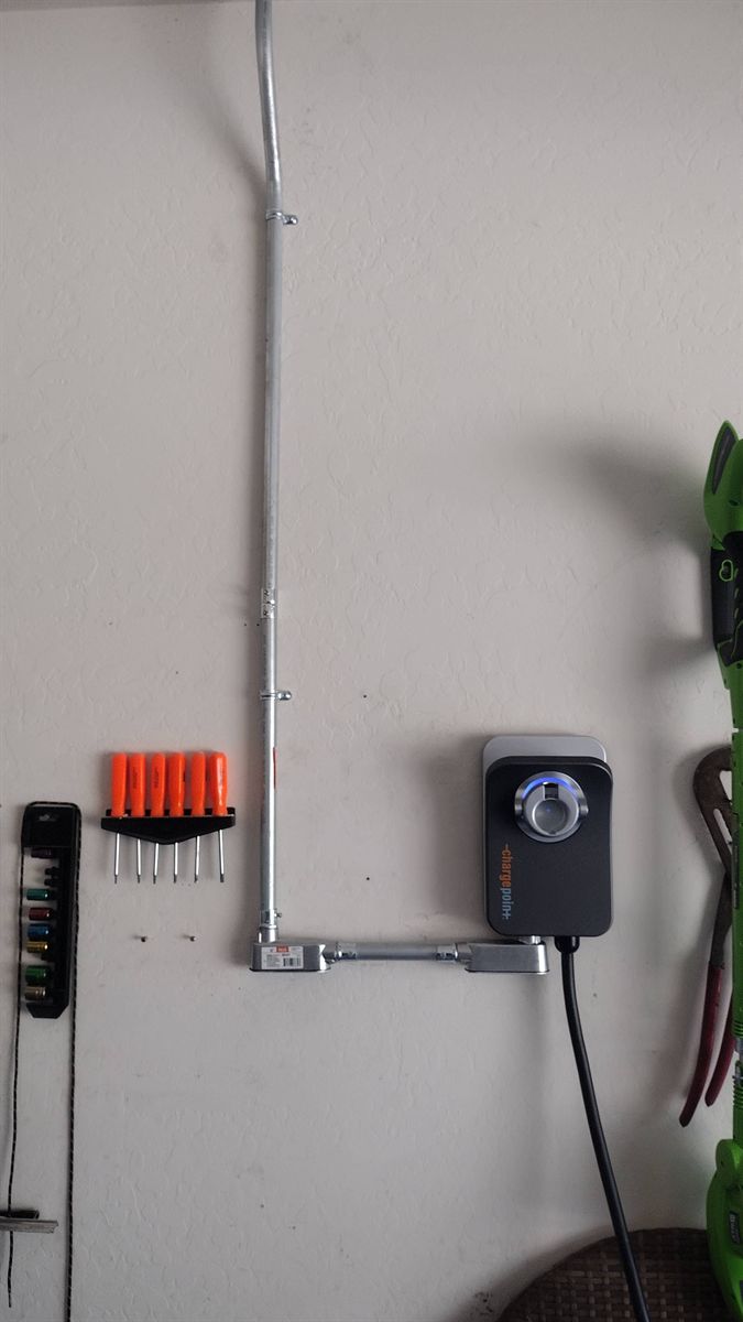 Level 2 charger fed by surface conduit on a garage wall