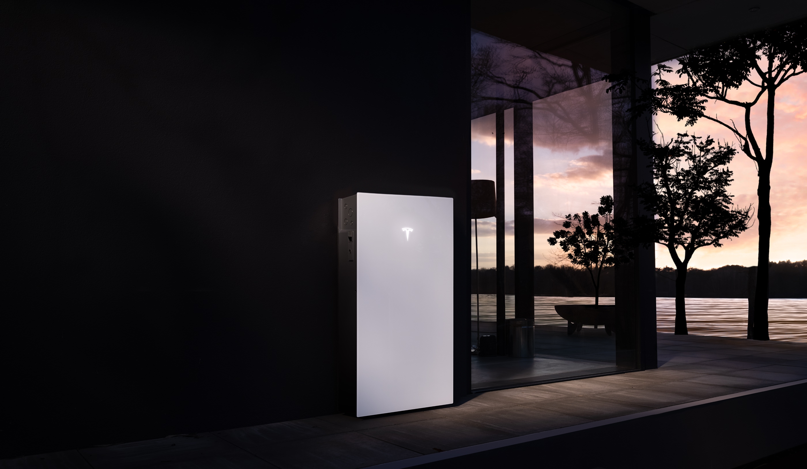 Tesla Powerwall mounted on an exterior wall at dusk