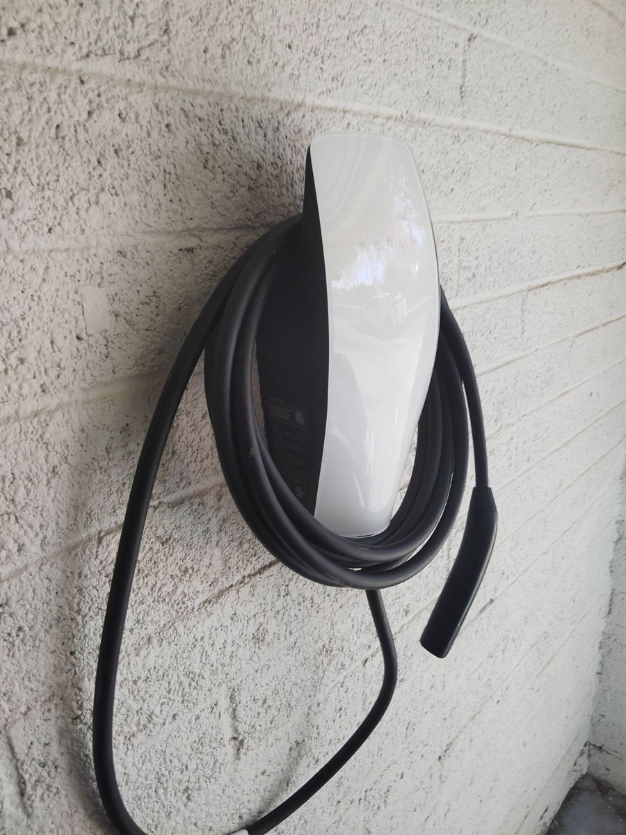 Tesla Wall Connector mounted on a block wall