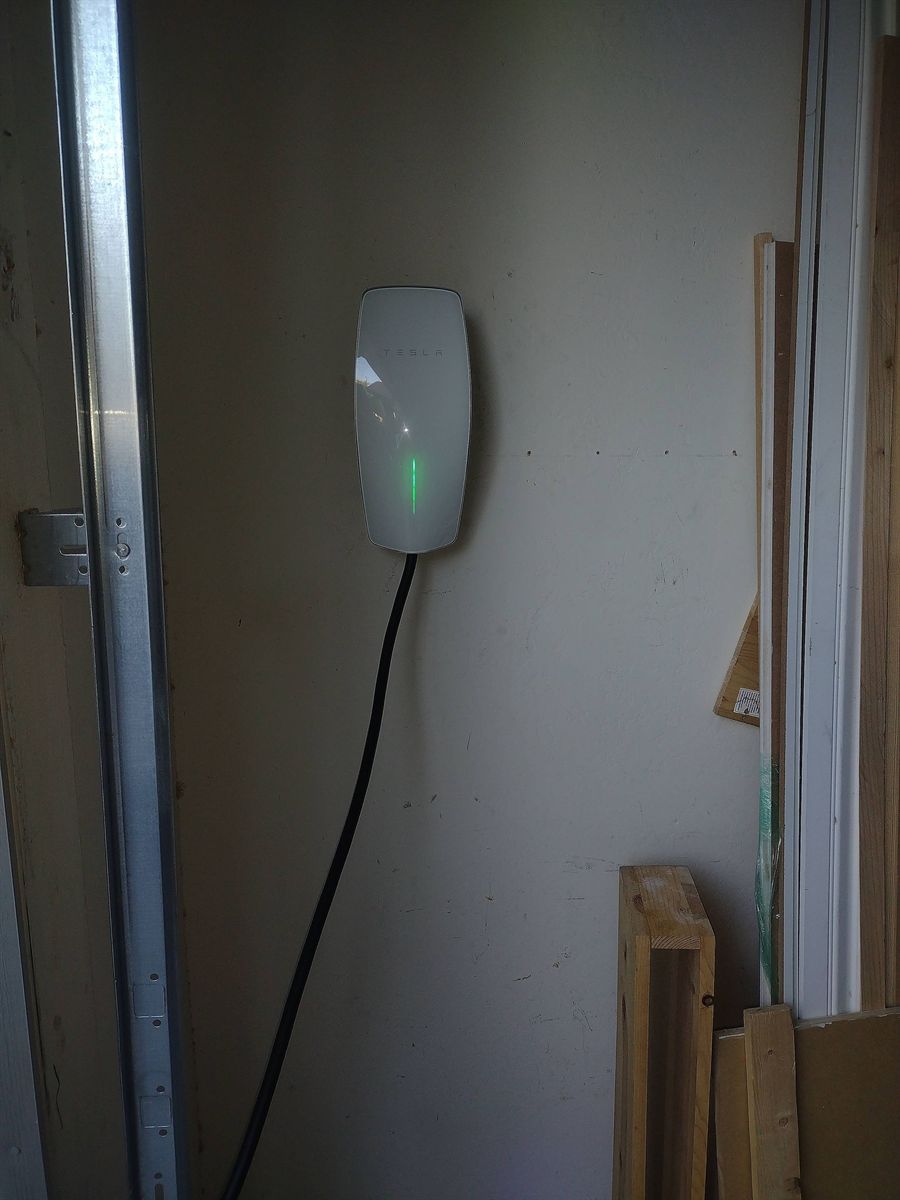 Tesla Wall Connector installed beside a garage door track