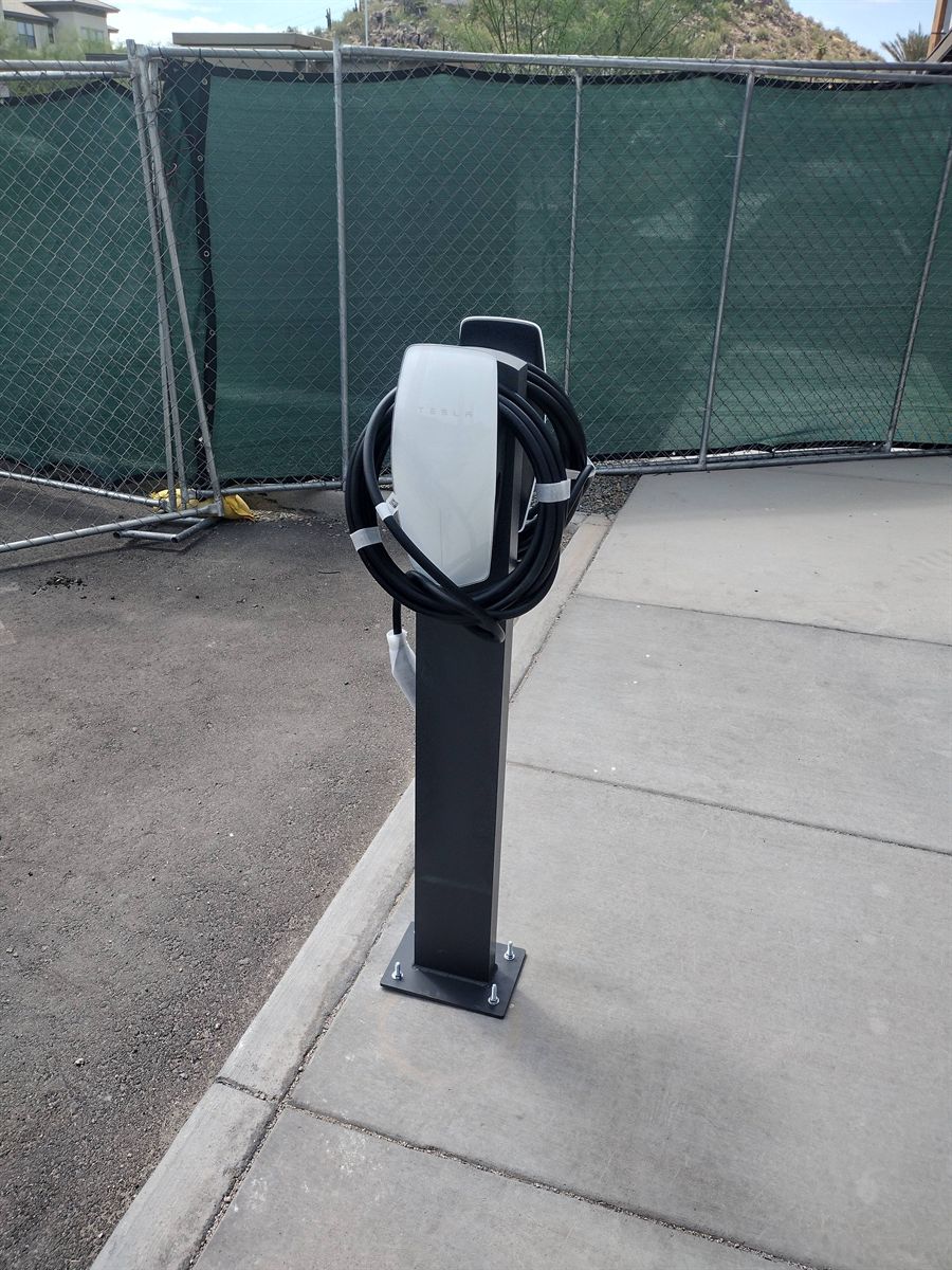 Tesla Wall Connector installed on a pedestal mount at a commercial site